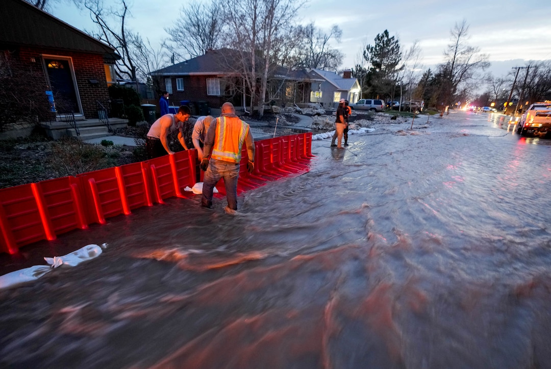(Francisco Kjolseth | The Salt Lake Tribune) Crews put up barriers along 1700 South in Salt Lake City to protect homes from the rising flow of Emigration Creek through Wasatch Hollow Park on Wednesday, April 12, 2023. 