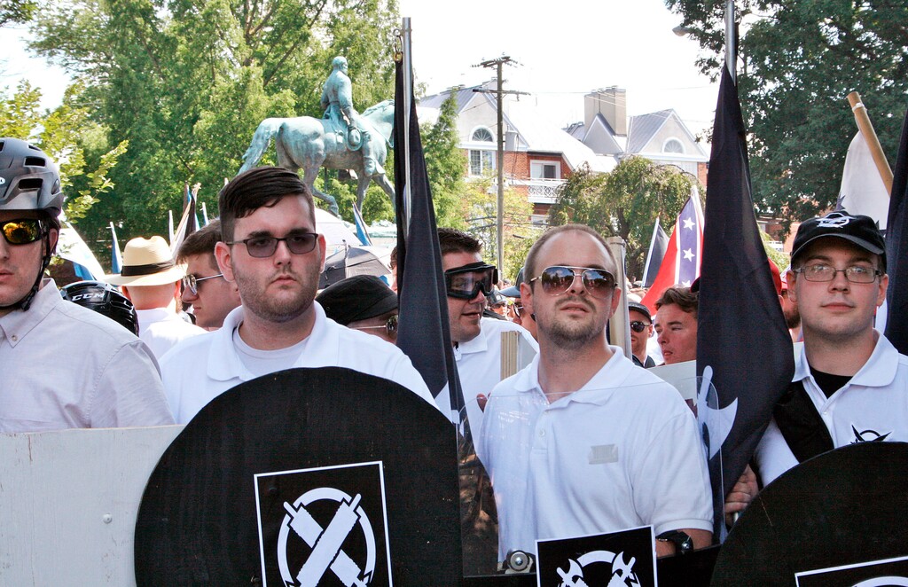 (Alan Goffinski | The Associated Press) In this Saturday, Aug. 12, 2017 file photo, James Alex Fields Jr., second from left, holds a black shield in Charlottesville, Va., where a white supremacist rally took place. The following week, Fields was charged with second-degree murder and other counts after authorities say he plowed a car into a crowd of people protesting the white nationalist rally.