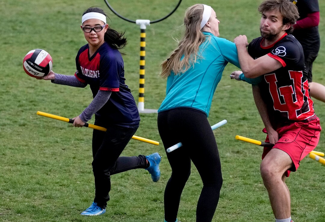 (Francisco Kjolseth | The Salt Lake Tribune) Hannah Winslow runs the quaffle (a volleyball) as Katie Ely handles defense on Porter Birchum as they practice the game of Quidditch based on the Harry Potter books at Reservoir Park in Salt Lake City on Wednesday, April 13, 2022. 