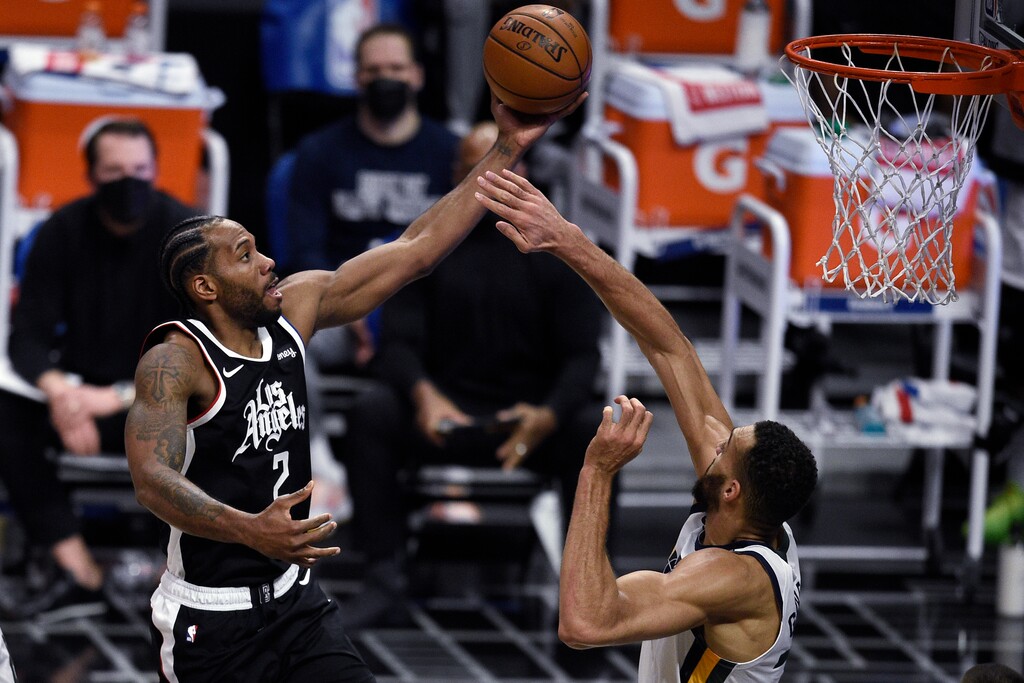 Los Angeles Clippers forward Kawhi Leonard, left, jumps up for a shot while Utah Jazz center Rudy Gobert defends during the first half of an NBA basketball game in Los Angeles, Friday, Feb. 19, 2021. (AP Photo/Kelvin Kuo)