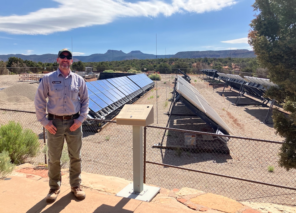 (Tim Fitzpatrick | The Salt Lake Tribune) Brian Maholy, facility manager for Natural Bridges National Monument, stands in front of the monument's solar array with the Bears Ears in the background.