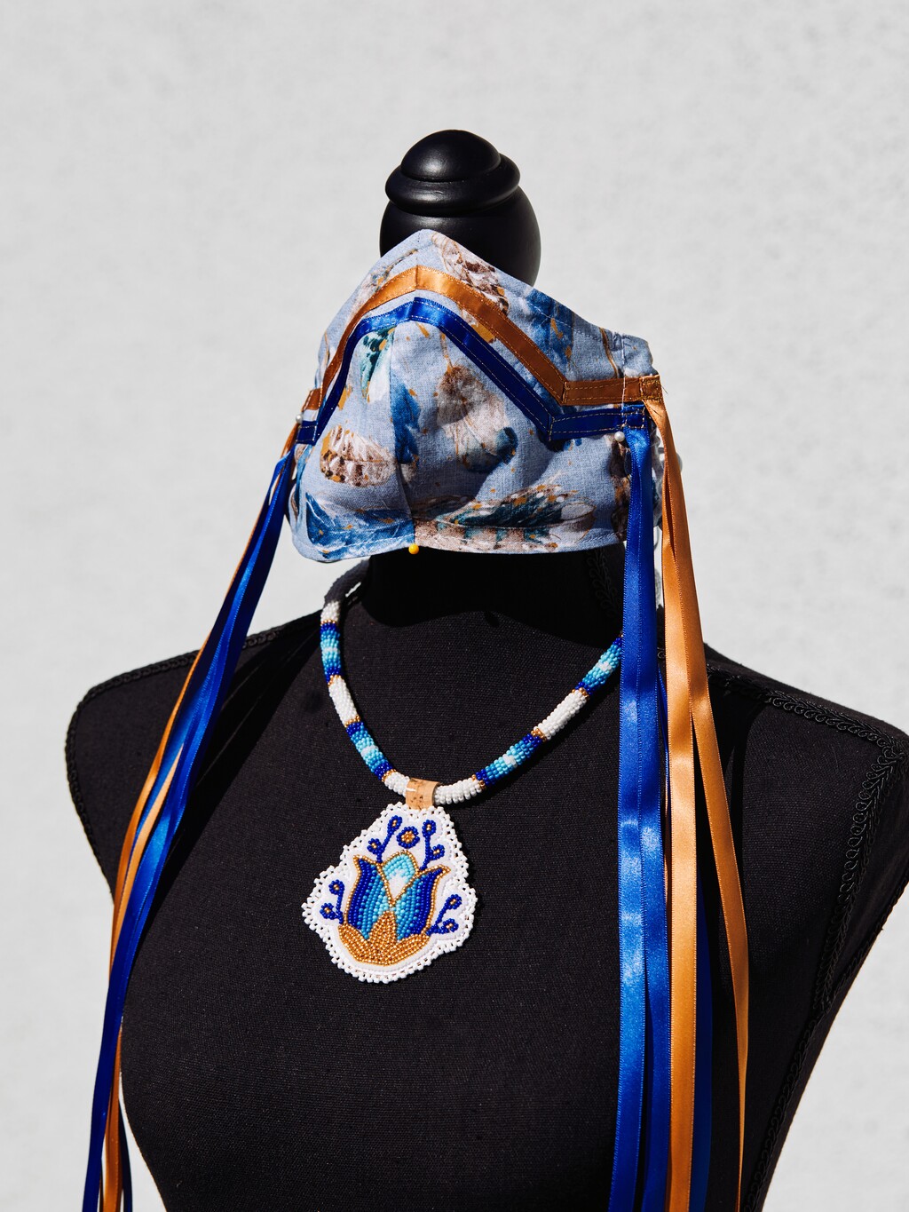 (Adam Amengual | The New York Times) A Navajo-inspired PPE mask and necklace created by Brighid Pulskamp is displayed in La Habra, Calif., on May 14, 2020. The mask and necklace will be auctioned for the UCLA American Indian Alumni Association’s scholarship fund.