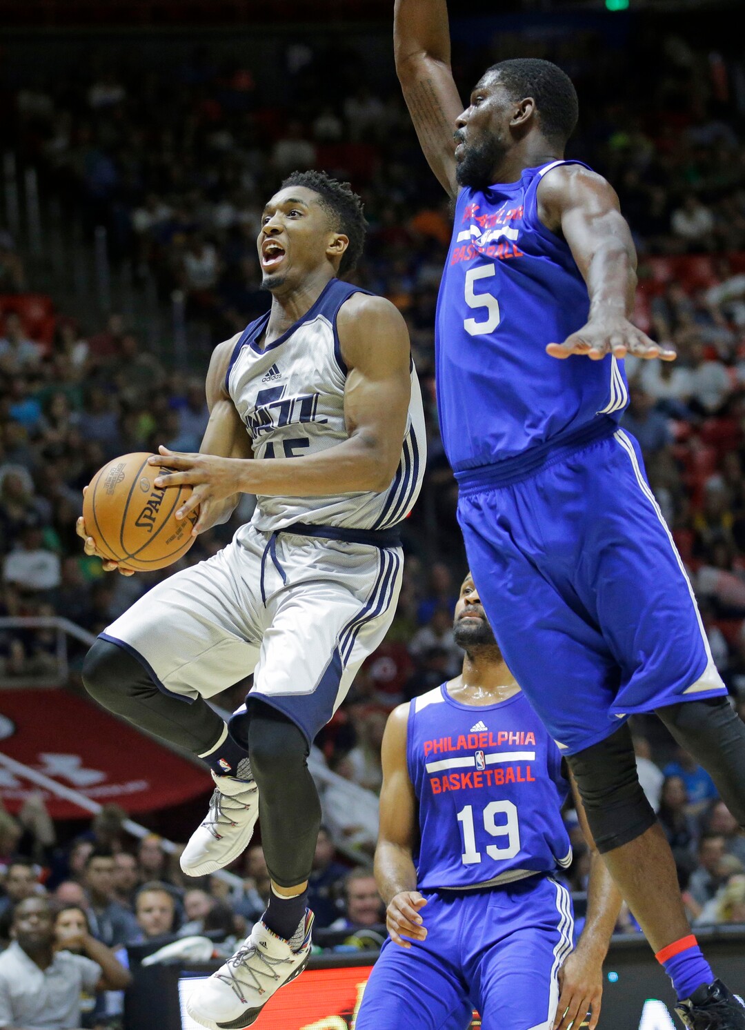 Utah Jazz guard Donovan Mitchell, left, goes to the basket as Philadelphia 76ers forward Alex Poythress (5) defends during the second half of an NBA summer league basketball game Wednesday, July 5, 2017, in Salt Lake City. (AP Photo/Rick Bowmer)