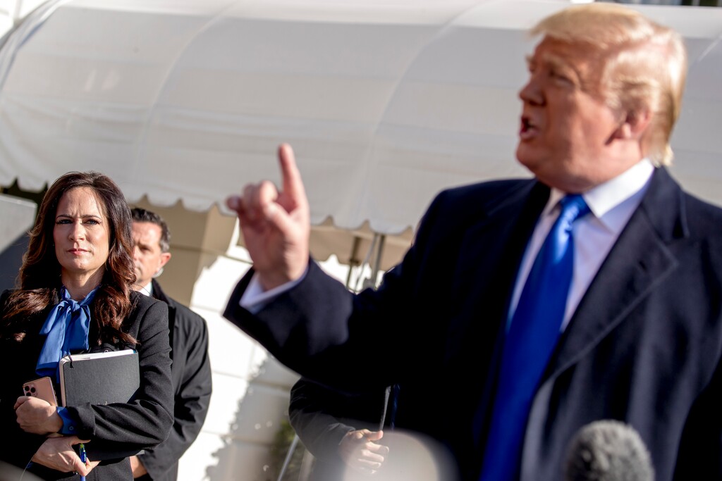 (AP Photo/Andrew Harnik) White House press secretary Stephanie Grisham, left, listens as President Donald Trump speaks to reporters on the South Lawn of the White House in Washington, Friday, Nov. 8, 2019, before boarding Marine One for a short trip to Andrews Air Force Base, Md. and then on to Georgia to meet with supporters.
