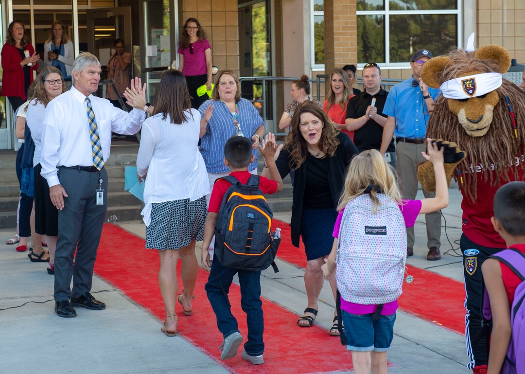 (Rick Egan  |  The Salt Lake Tribune)         Jeri Rigby, the new principal of Copperview Elementary School, greets students along with Leo the Lion and other teachers, as they walk the red carpet on the first day of school, Monday, Aug. 19, 2019.