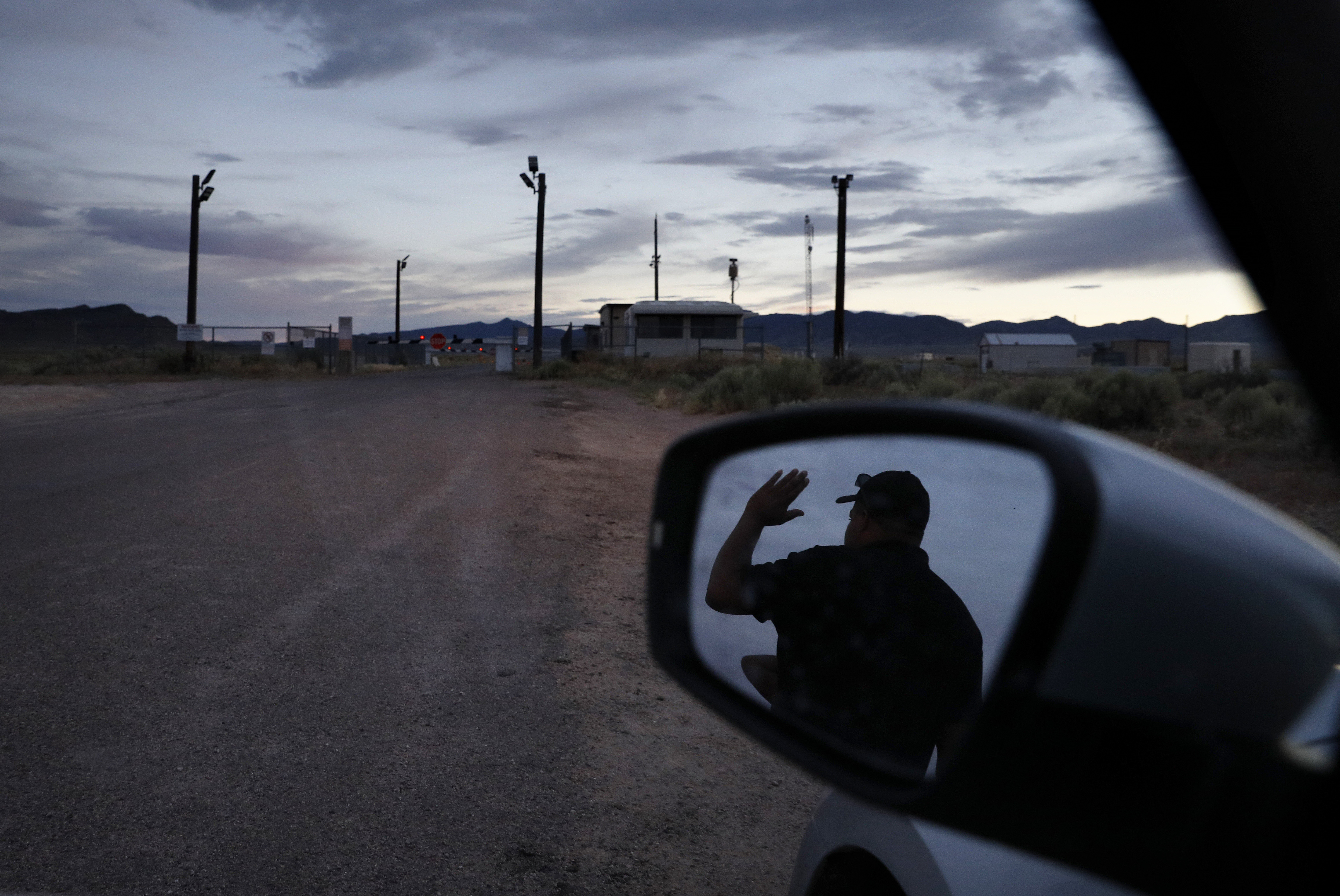 (John Locher | AP Photo) In this July 22, 2019 photo, Terris Williams, reflected in a mirror, visits an entrance to the Nevada Test and Training Range near Area 51 outside of Rachel, Nev. The U.S. Air Force has warned people against participating in an internet joke suggesting a large crowd of people "storm Area 51," the top-secret Cold War test site in the Nevada desert.