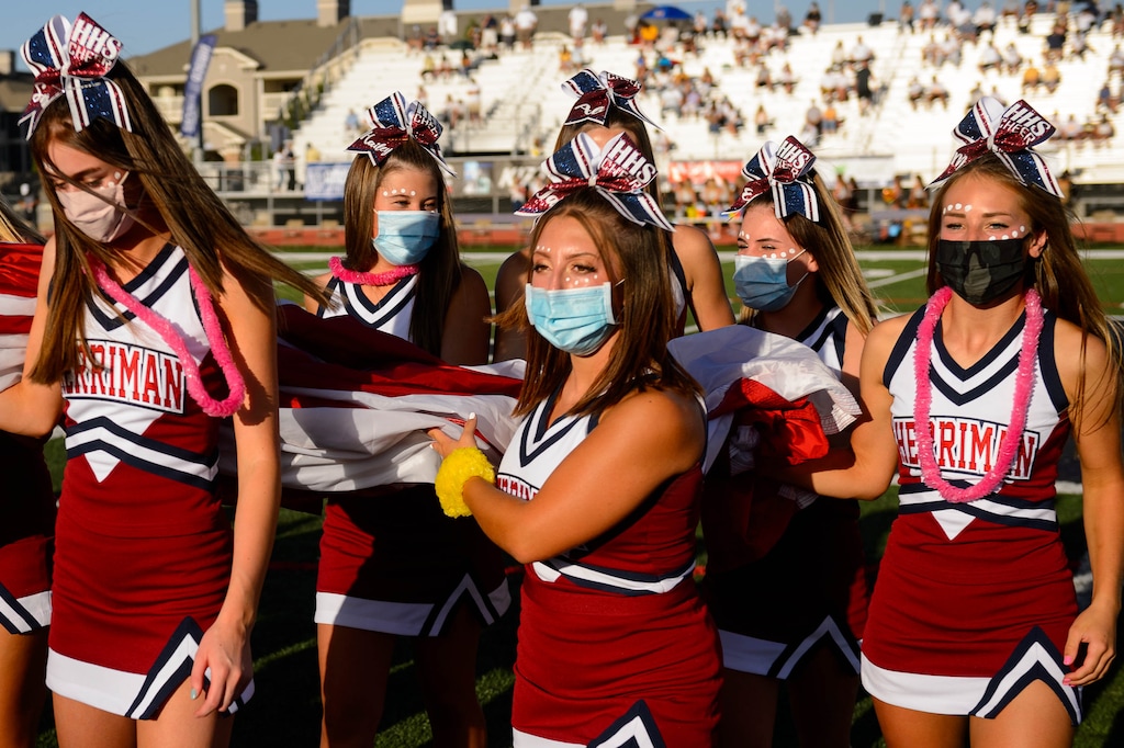 (Trent Nelson  |  The Salt Lake Tribune) Herriman cheerleaders hold a flag during the National Anthem while hosting Davis High School football, in Herriman on Thursday, Aug. 13, 2020.