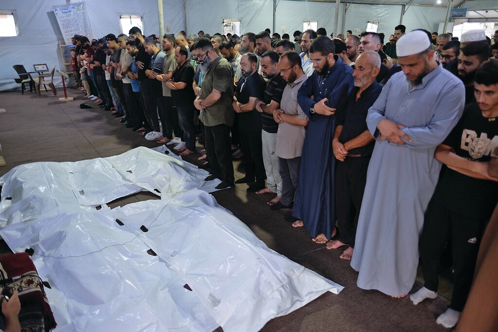 Mourners pray over the bodies of Palestinian Adham Nesman and his family, who were killed in an Israeli airstrike, during their funeral in Gaza city, Saturday, July 18, 2026. (AP Photo/Jehad Alshrafi)