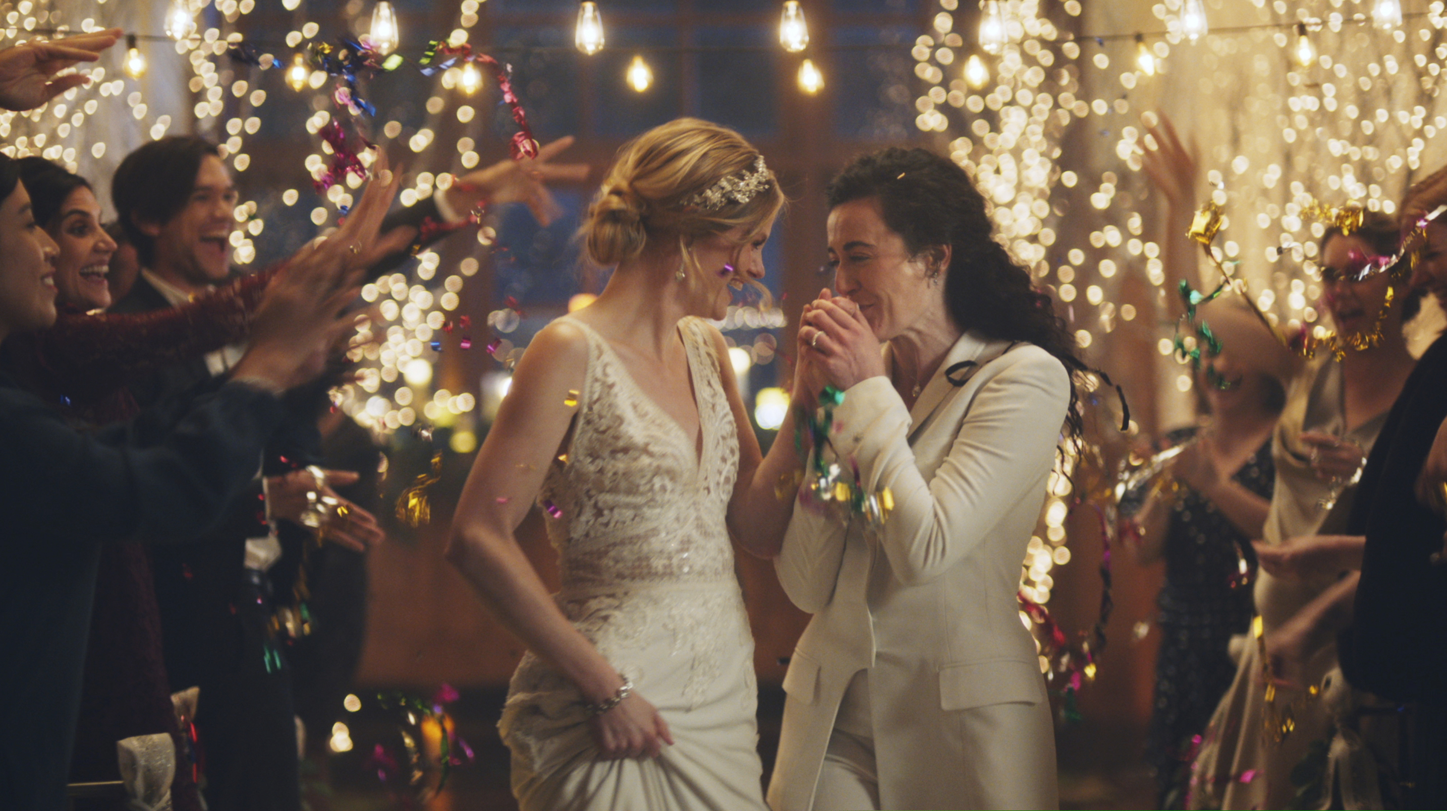 (Zola via AP) This image made from undated video provided by Zola shows a scene of its advertisement. Under pressure from a conservative advocacy group, The Hallmark Channel has pulled the ads for wedding-planning website Zola that featured same-sex couples, including two brides kissing. The family-friendly network, which is in the midst of its heavily watched holiday programming, removed the ads because the controversy was a distraction, a spokesperson said in an interview on Saturday, Dec. 14, 2019.