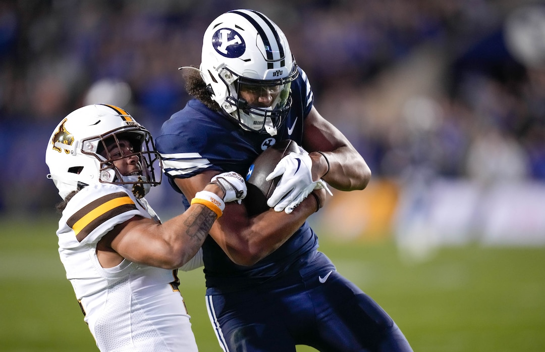 (Francisco Kjolseth | The Salt Lake Tribune) Wyoming Cowboys cornerback Cameron Stone (4) tries to take down Brigham Young Cougars wide receiver Keanu Hill (1) as he scores a touchdown in football action between the Brigham Young Cougars and the Wyoming Cowboys at LaVell Edwards Stadium in Provo, on Saturday, Sept. 24, 2022.