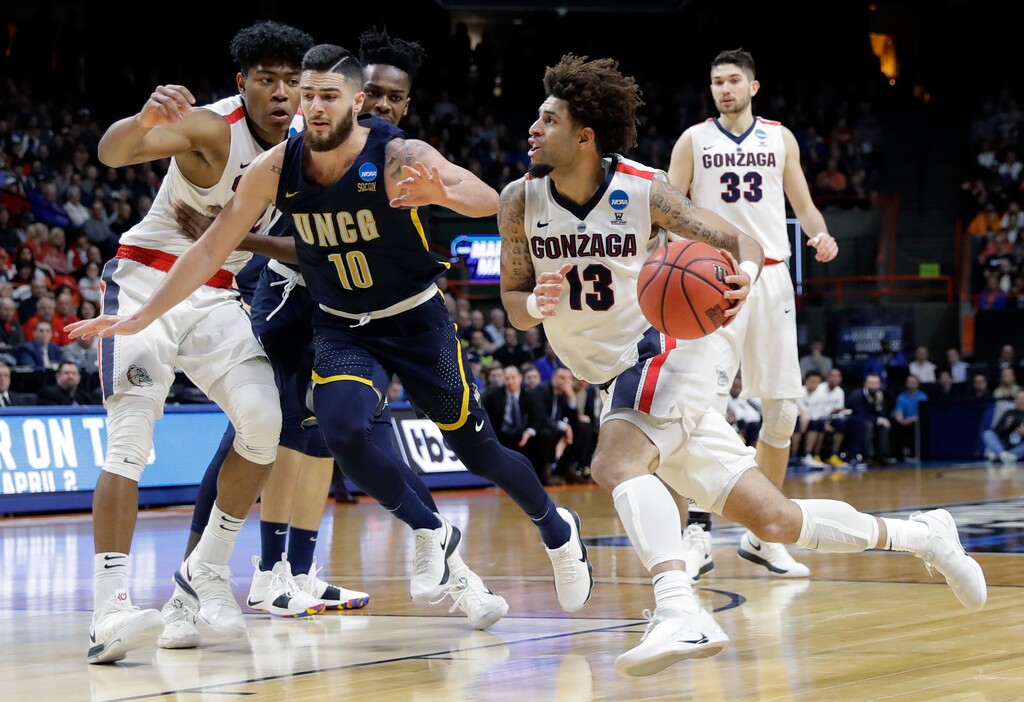 Gonzaga guard Josh Perkins (13) drives against UNC-Greensboro guard Francis Alonso (10) as Gonzaga forward Rui Hachimura looks on at left, during the second half of an NCAA college basketball tournament first-round game, Thursday, March 15, 2018, in Boise, Idaho. (AP Photo/Otto Kitsinger)