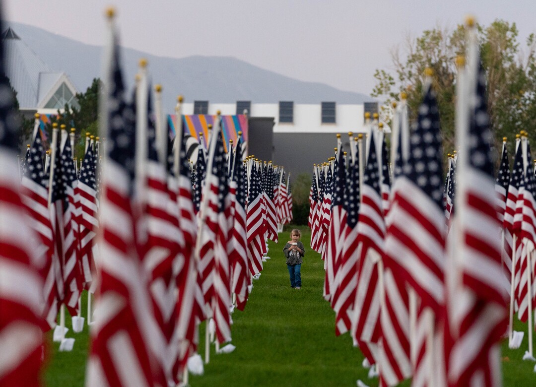 (Francisco Kjolseth | The Salt Lake Tribune) The sun rises on Saturday, Sept. 11, 2021, as people visit the Utah Healing Field in Sandy, part of the nonprofit Colonial Flag Foundation, who posted 3,000 flags to honor the fallen. The display is free to the public and open now through Sept. 13.