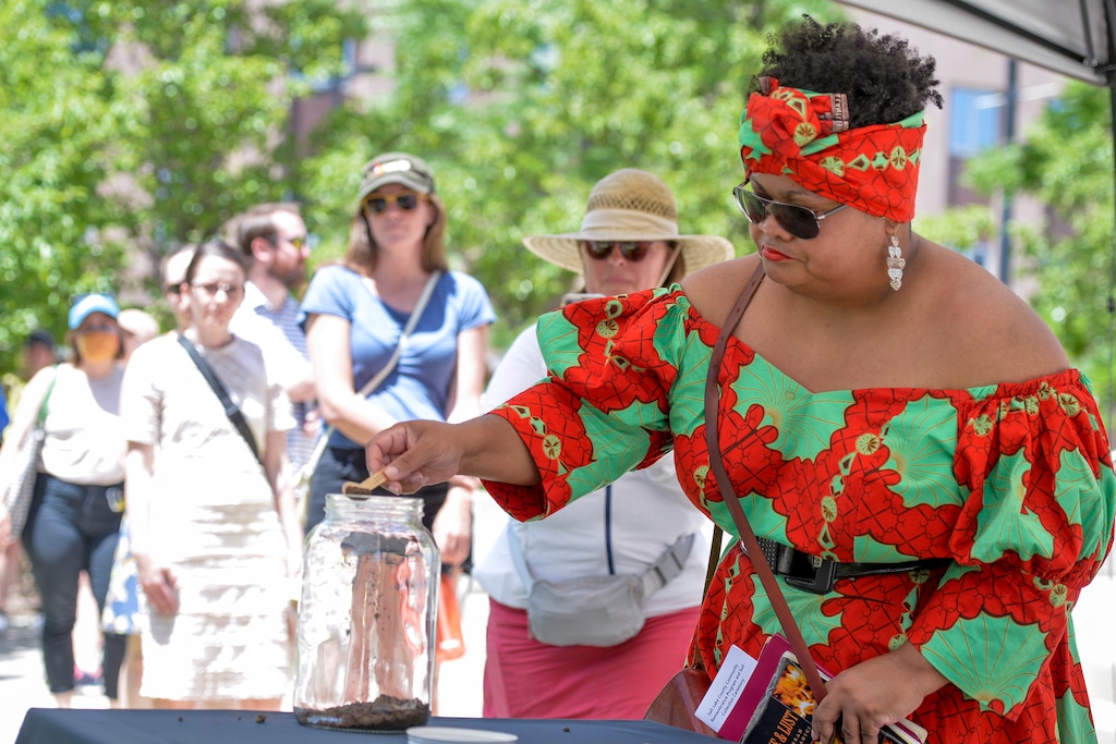 (Chris Samuels | The Salt Lake Tribune) Michaelle Martial places soil in a jar to commemorate the lynching of William “Sam Joe” Harvey at the Bennet Federal Building, Saturday, June 11, 2022. Soil from the location was collected and will be sent to the National Museum for Peace and Justice.