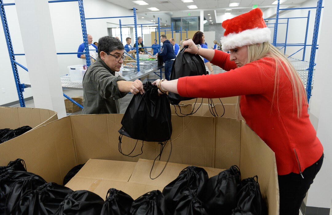 (Francisco Kjolseth  |  The Salt Lake Tribune)  Chase Hathaway and Wendy Reynolds join other USANA staff as they volunteer their time assembling food bags for at-risk youth at the newly-renovated packing and storage facility next to the headquarters of the Salt Lake City company on Wed. Dec. 11, 2019. The USANA Foundation has acquired two local charities, Kids Next Door and KidsEat!, that provides hundreds of food bags every week for the kids for the weekends and during long school breaks.