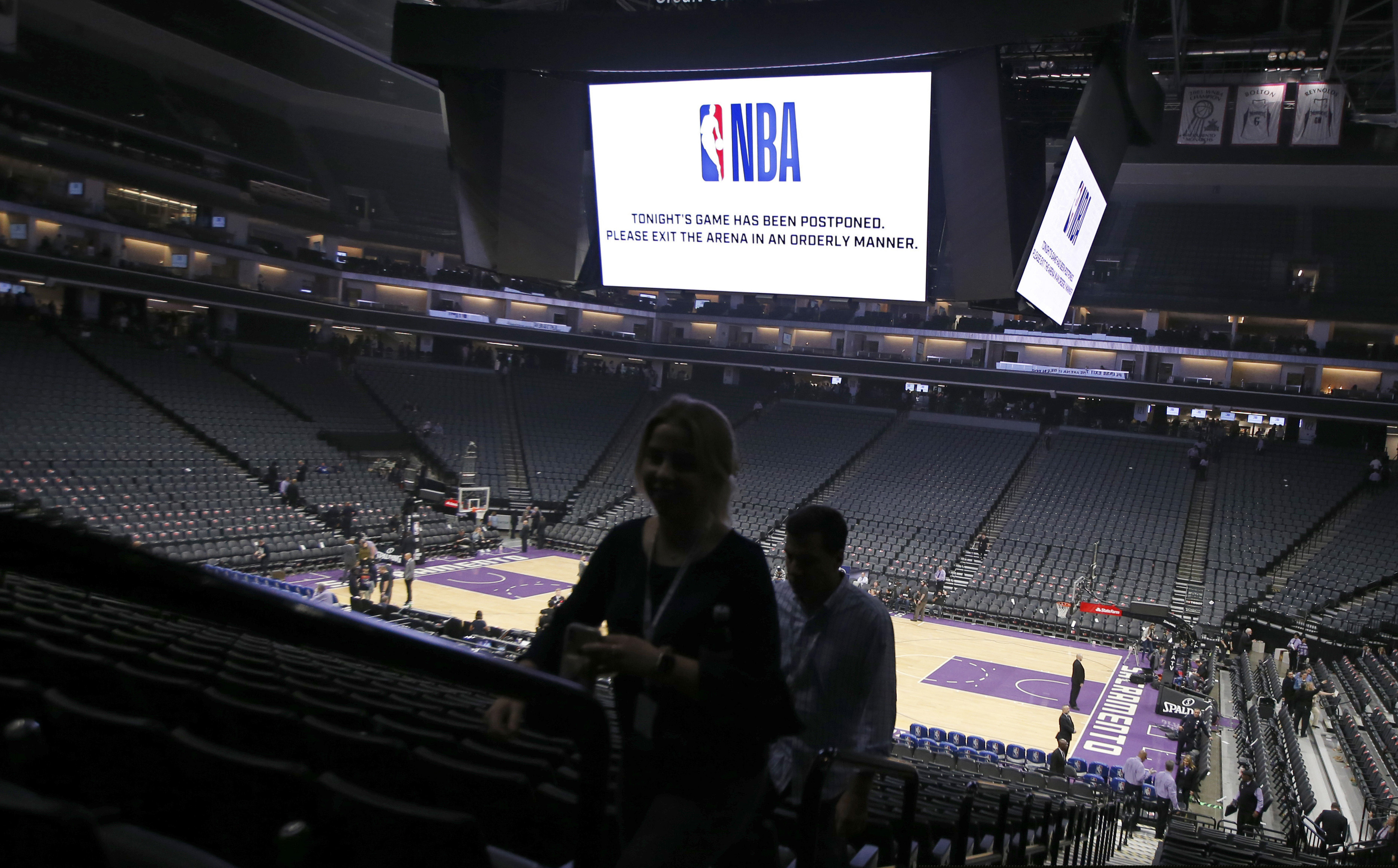 (Rich Pedroncelli | AP file photo) Fans leave the Golden 1 Center  in Sacramento, Calif., after the NBA basketball game between the New Orleans Pelicans and Sacramento Kings on March 11, 2020, was postponed at the last minute over an "abundance of caution" after a player for the Jazz tested positive for the coronavirus.