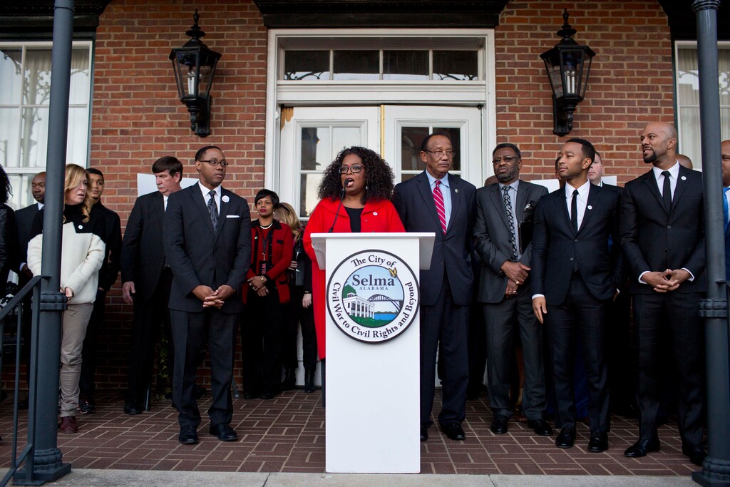 Oprah Winfrey address the crowd before she marches Edmund Pettus Bridge in honor of Martin Luther King Jr., Sunday, Jan. 18, 2015, in Selma, Ala. Winfrey joined some of the cast to promote the movie "Selma." (AP Photo/Brynn Anderson)