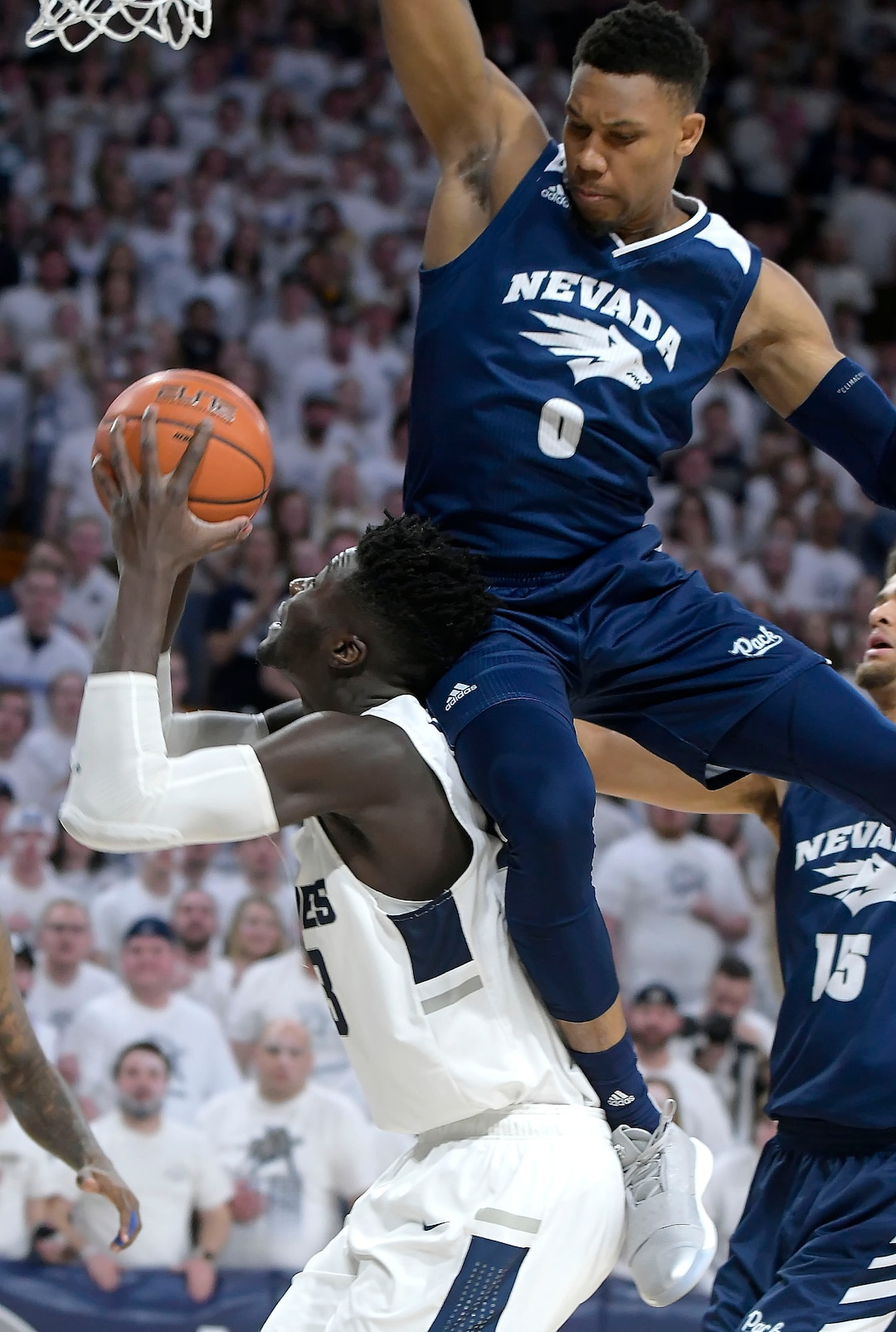 (Eli Lucero  |  The Herald Journal via AP) Utah State center Neemias Queta takes a shot as Nevada forward Tre'Shawn Thurman (0) defends during an NCAA college basketball game, Saturday, March 2, 2019, in Logan, Utah.