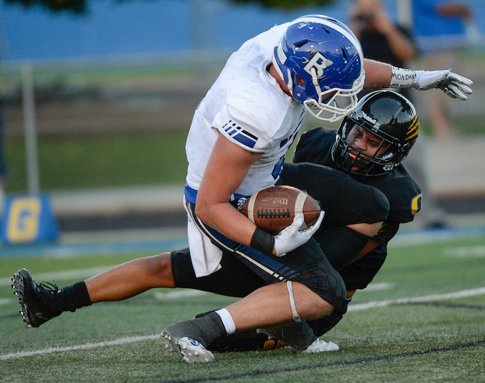 (Francisco Kjolseth  |  The Salt Lake Tribune)  Bingham's Briasen Harward is taken down by Orem's Buju Tuisavura in the first half of the game, Thursday, Aug. 16, 2018 in Orem.