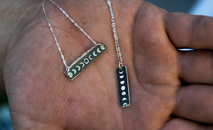 (Leah Hogsten | The Salt Lake Tribune) Artist Ben Cosner, owner of The Bearded Jeweler made necklaces of the upcoming eclipse at the 9th Annual Craft Lake City DIY Festival, Friday, August 11, 2017 with over 250 local artisans, DIY engineers, vintage vendors, and craft food creators. The festival also features live music and dance performances, local food trucks and runs through Sunday, August 13th at the Gallivan Center.