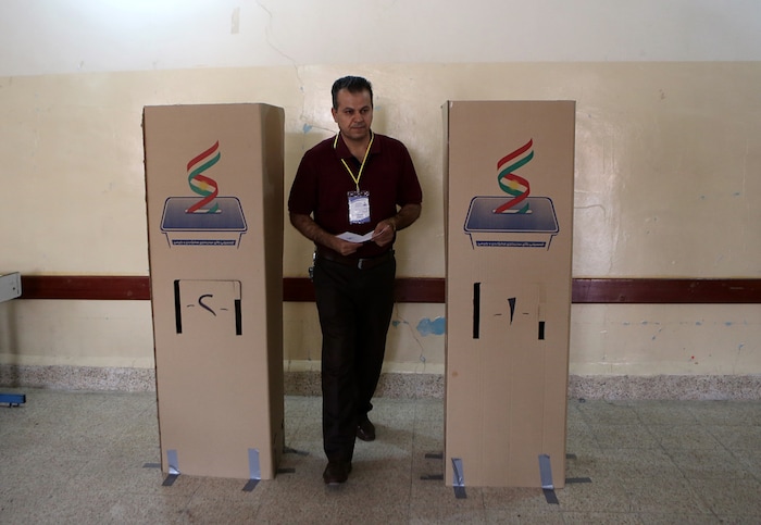 An Iraqi Kurdish man leaves the voting booth to cast his ballot in the referendum on independence from Iraq in Irbil, Iraq, Monday, Sept. 25, 2017. (AP Photo/Khalid Mohammed)