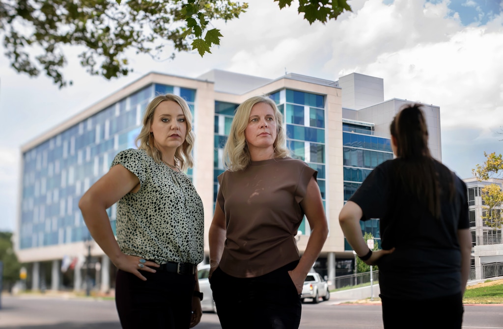 (Francisco Kjolseth | The Salt Lake Tribune) Social workers Juli Miller, left, and Emily Long, center, with another former caseworker for the Salt Lake County District Attorney’s Division of Victim and Survivor Support Services, who all worked in the DA’s building in background, are pictured on Tuesday, July 28, 2026. All three women previously worked for the division and alleged they experienced hostile behavior from their superiors.