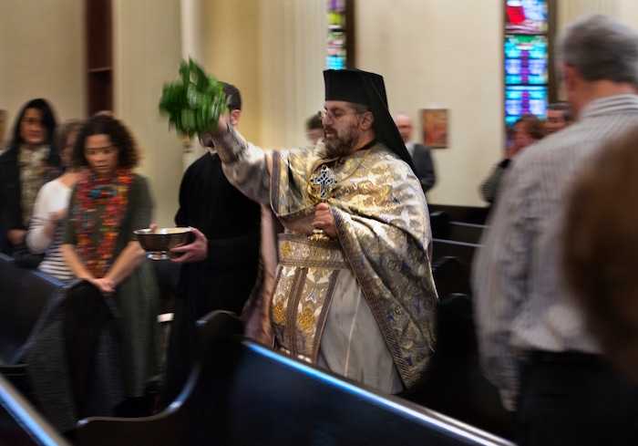 (Scott Sommerdorf | The Salt Lake Tribune)
The Very Rev. Archimandrite George Nikas blesses congregants with holy water from a bouquet of basil as he conducts the Epiphany service (also called Theophany in Orthodox), as holy water is blessed, at Holy Trinity Cathedral, Saturday, January 6, 2018.