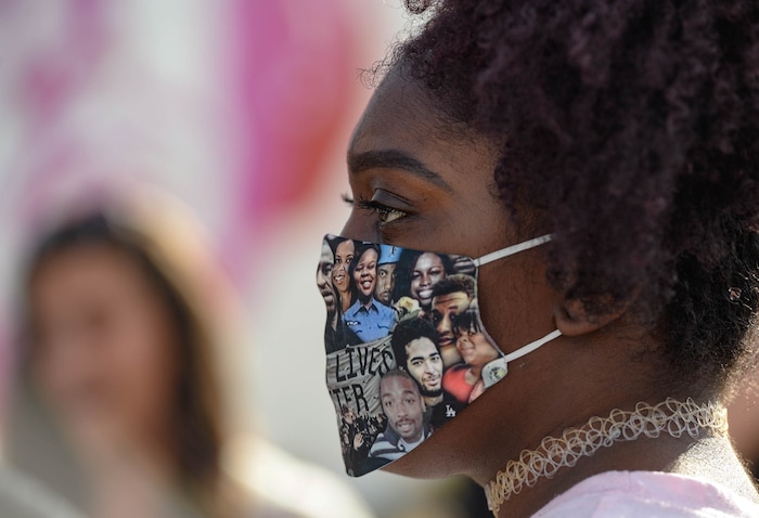 (Francisco Kjolseth  |  The Salt Lake Tribune) Taylor Natt joins the vigil organized by family of Dillon Taylor on the six-year anniversary of his death by the murals of people killed by police near 800 South and 300 West in Salt Lake City on Tuesday, August 11, 2020. Multiple families who’s loved one’s are depicted on the walls joined the vigil as they moved from portrait to portrait to remember them.