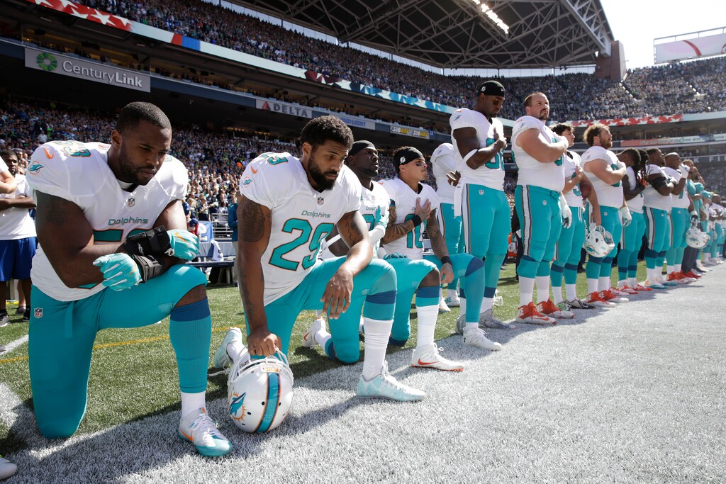 (AP Photo/Stephen Brashear) In this Sept. 11, 2017 file photo, from left, Miami Dolphins' Jelani Jenkins, Arian Foster, Michael Thomas, and Kenny Stills, kneel during the singing of the national anthem before an NFL football game against the Seattle Seahawks in Seattle. The anthem is played before the start of every U.S. major sporting event, where fans and players are expected to salute the flag by placing a hand over the heart while singing along. Not doing so is considered unpatriotic by some. The anthem has also been used by athletes as a way to protest.