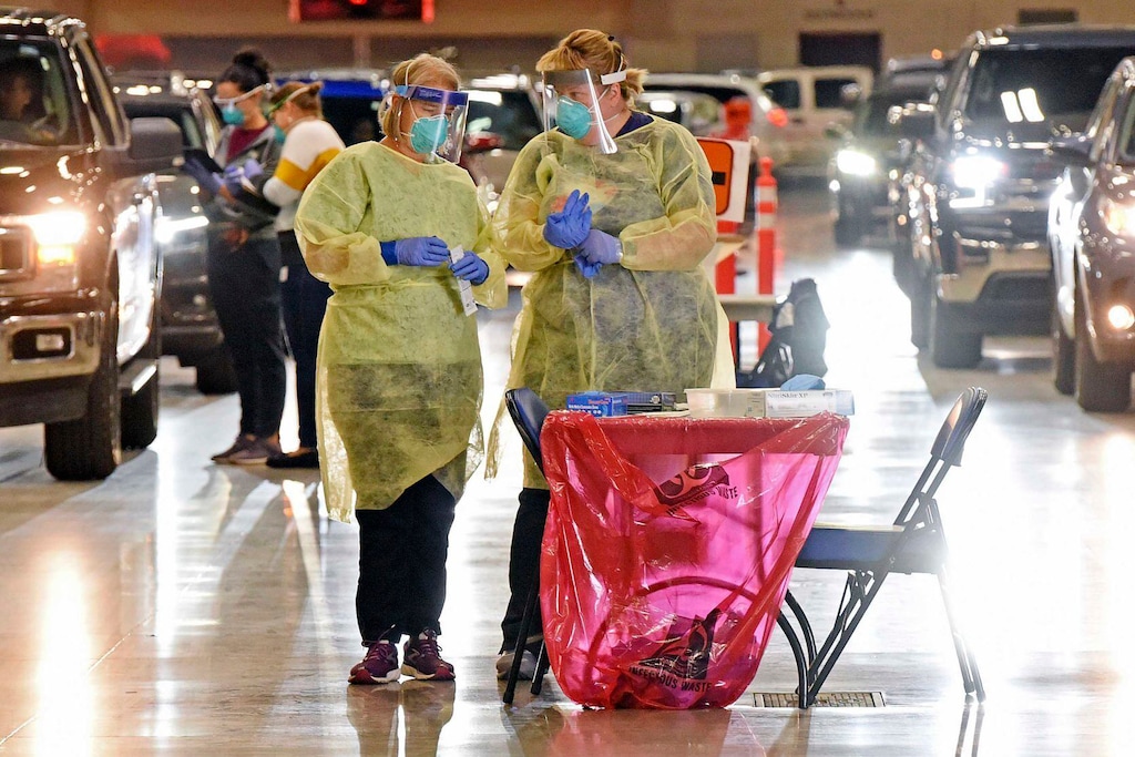 (Tom Stromme | The Bismarck Tribune via AP, File)

In this Sept. 8 photo, Bismarck-Burleigh Public Health nurses Crys Kuntz, left, and Sara Nelson confer inside the Bismarck Event Center in Bismarck, N.D., where vehicles were lined up for the weekly drive-thru COVID-19 testing. The coronavirus tightened its grip on the American heartland, with hospitals in Wisconsin and North Dakota running low on space, and the NFL postponing a game over an outbreak that's hit the Tennessee Titans football team.