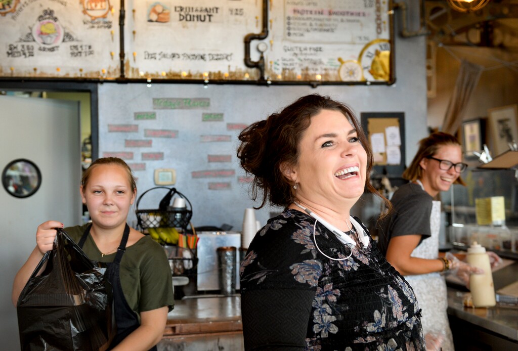 (Leah Hogsten | The Salt Lake Tribune)  Create Donuts owner LaDonnia Jones, center, and her employees Sophi Jefferson and Chloe Crandall, right, laugh with customers a day before the dessert shop closed its doors in late July.