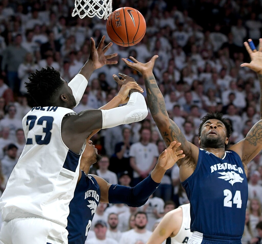 Utah State center Neemias Queta (23) fights for a rebound against Nevada forward Tre'Shawn Thurman (0) and forward Jordan Caroline (24) during an NCAA college basketball game, Saturday, March 2, 2019, in Logan, Utah. (Eli Lucero/The Herald Journal via AP)