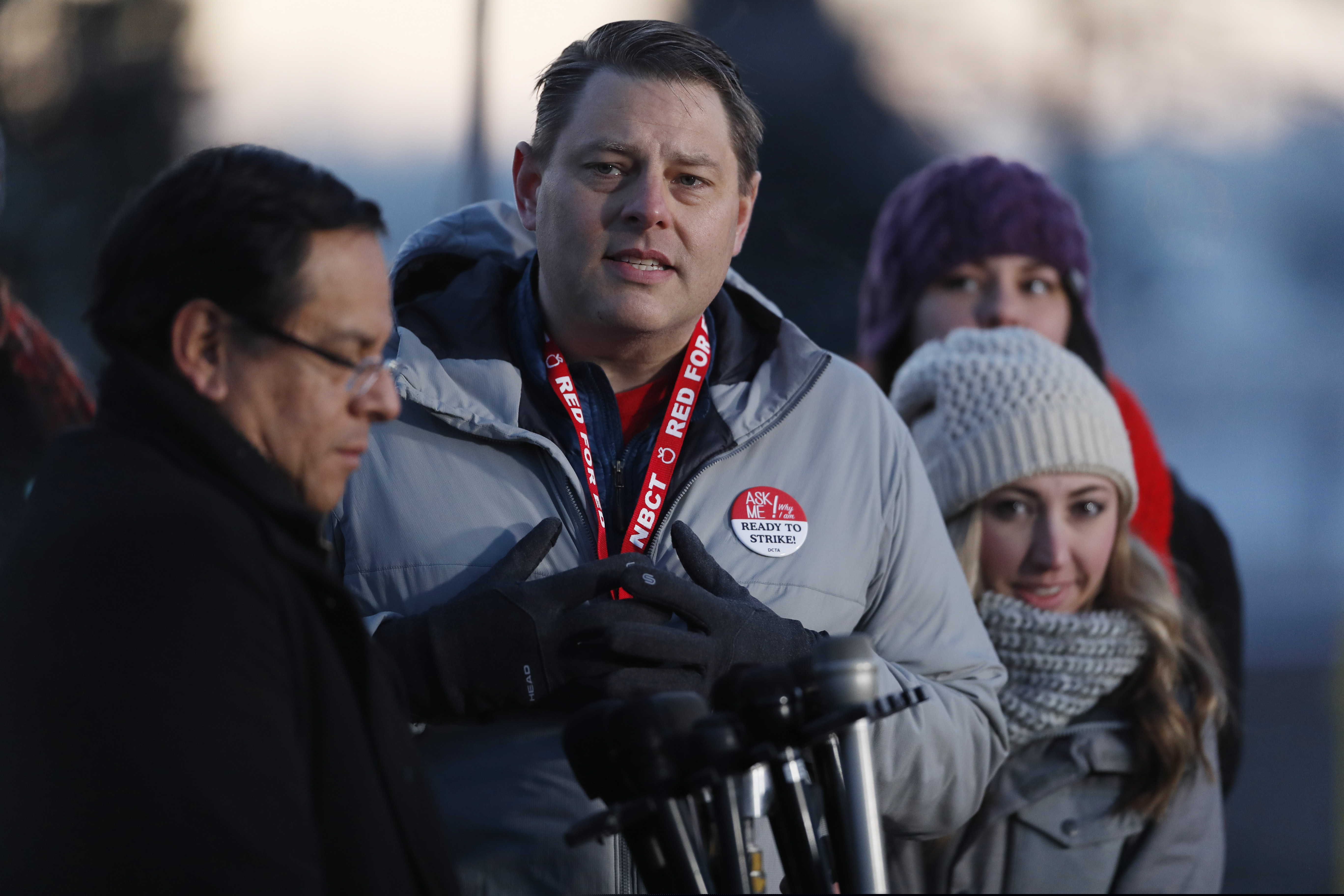 Rob Gould, center, a special education teacher and lead negotiator for the Denver Classroom Teachers Association, speaks during a news conference outside South High School early Monday, Feb. 11, 2019, in Denver. The strike on Monday is the first for teachers in Colorado in 25 years after failed negotiations with the school district over base pay. (AP Photo/David Zalubowski)