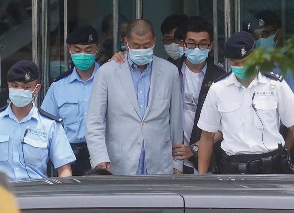 (AP Photo)
Hong Kong media tycoon Jimmy Lai, center, who founded the local newspaper Apple Daily, is escorted by police from the leave the Apple Daily headquarters in Hong Kong on Aug. 10. Lai was arrested on suspicion of collusion with foreign powers, his aide said, in the highest-profile use yet of the new national security law Beijing imposed on the city after protests last year.