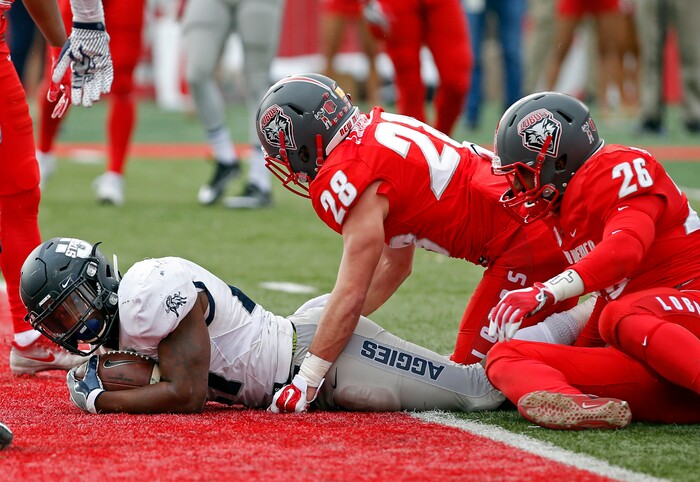 Utah State running back LaJuan Hunt, left, scores a touchdown under the look of New Mexico safety Jake Rothschiller (28) and linebacker Sitiveni Tamaivena (26) during the first half of an NCAA college football game in Albuquerque, N.M., Saturday, Nov. 4, 2017. (AP Photo/Andres Leighton)