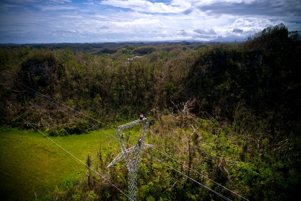 In this Sunday, Oct. 15, 2017 photo, Whitefish Energy Holdings workers stand on towers to restore lines damaged by Hurricane Maria in Barceloneta, Puerto Rico. Whitefish CEO Andy Techmanski said Whitefish was making progress on the line that carries about 230,000 volts to San Juan from the Aguirre power plant in the south, which will vastly increase the amount of power reaching the capital. (AP Photo/Ramon Espinosa)
