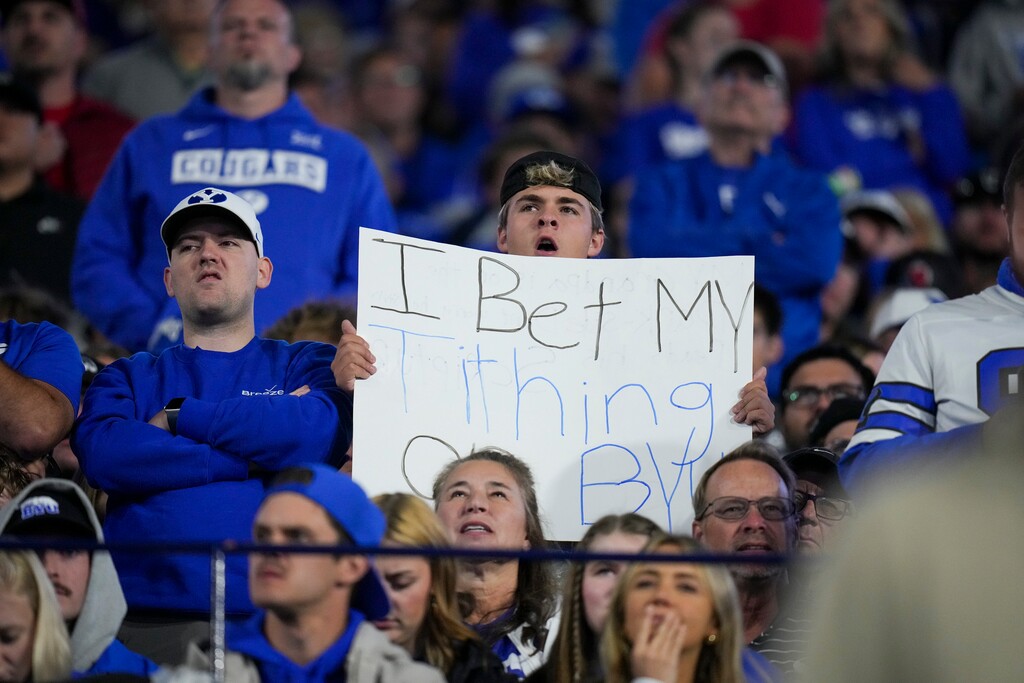 (Bethany Baker  |  The Salt Lake Tribune) A BYU Cougars fan holds up a sign during the game between the BYU Cougars and the Utah Utes in Provo on Saturday, Oct. 18, 2025.