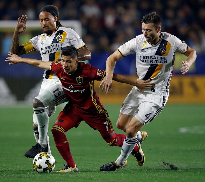 Real Salt Lake forward Jefferson Savarino, center, holds back Los Angeles Galaxy midfielder Jermaine Jones, left, and defender Dave Romney from the ball during the second half of an MLS soccer game in Carson, Calif., Saturday, Sept. 30, 2017. (AP Photo/Alex Gallardo)