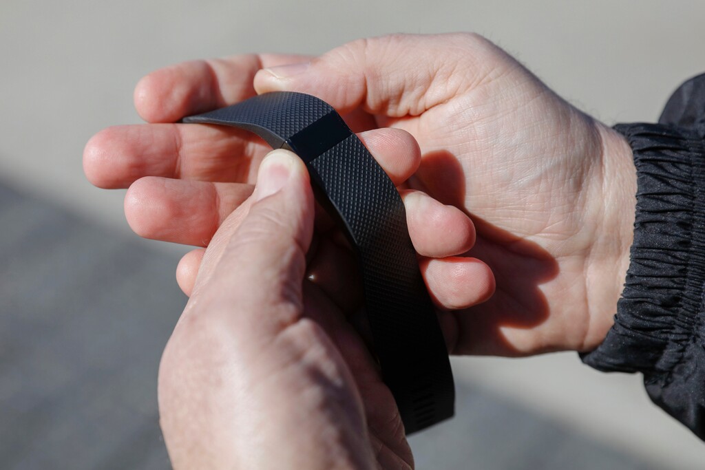 In this Monday, Feb. 29, 2016, photo, Brett Broviak, a manager of respiratory and sleep services at IU Health North Hospital, shows off his Fitbit fitness tracker for the camera on the hospital's campus in Carmel, Ind. Companies and insurers looking to reduce health-care costs are turning to incentives and may soon start rewarding you for wearing a fitness device that tracks your steps, heart rate and more. (AP Photo/AJ Mast)