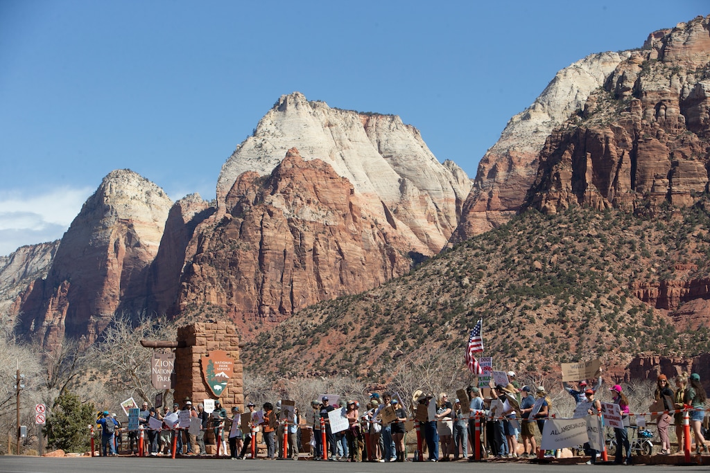 (Chris Caldwell | Special to The Tribune) Demonstrators line the street near the south entrance of Zion National Park Saturday, March 1, 2025, protesting the firing of National Park Service employees.