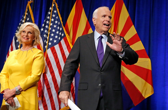 FILE - In this Nov. 8, 2016, file photo, Sen. John McCain, R-Ariz., right, waves to supporters at his victory party as wife Cindy McCain, left, joins him on stage as he announces his victory over Democratic challenger Rep. Ann Kirkpatrick in Phoenix. (AP Photo/Ross D. Franklin, File)
