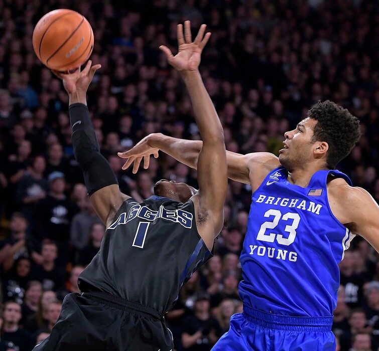 Utah State guard Koby McEwen (1) takes a shot as BYU forward Yoeli Childs (23) defends during an NCAA college basketball game, Saturday, Dec. 2, 2017, in Logan, Utah. (Eli Lucero/The Herald Journal via AP)