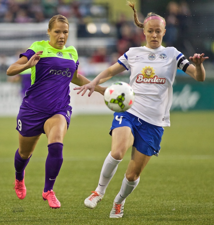 FC Kansas City defender Becky Sauerbrunn, right, beats Seattle Reign FC midfielder Merritt Mathias to the ball during the first half of the NWSL soccer championship match in Portland, Ore., Thursday, Oct. 1, 2015. (AP Photo/Craig Mitchelldyer)