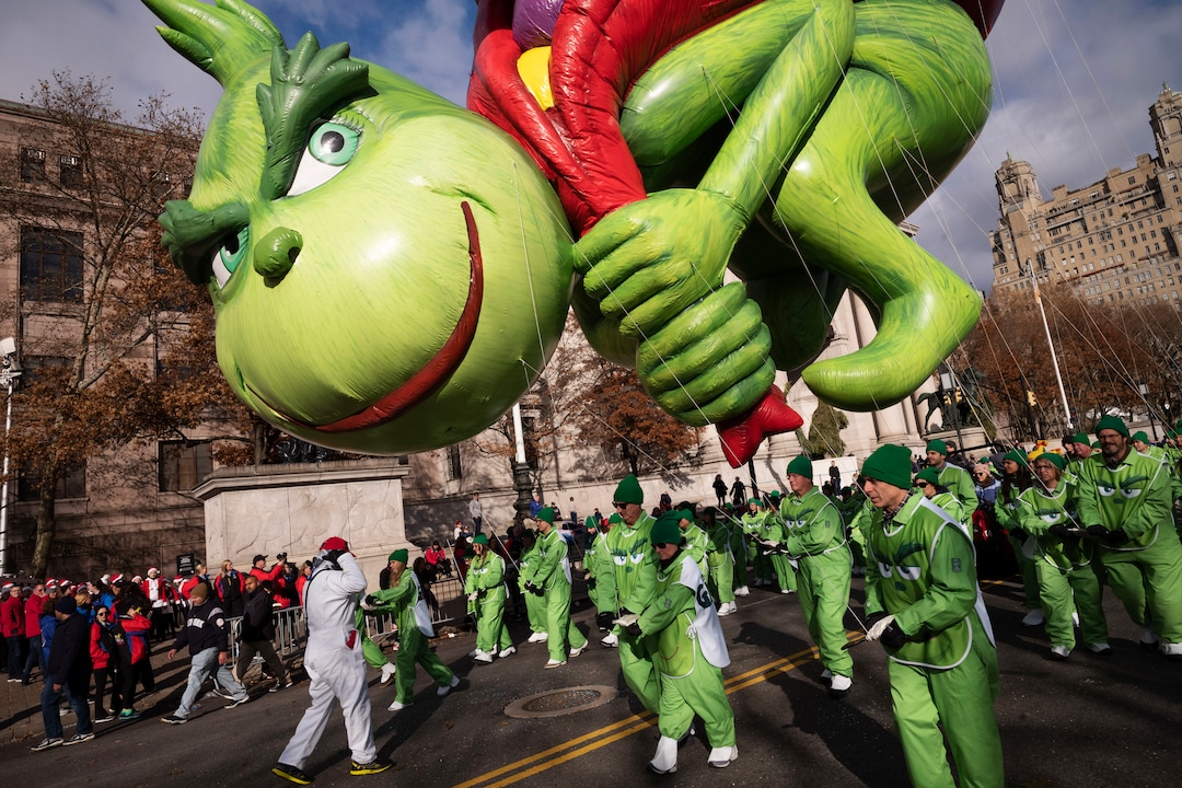 (Mark Lennihan | AP)  Balloon handlers hold Dr. Seuss' The Grinch close to the ground as strong winds affect the Macy's Thanksgiving Day Parade, Thursday, Nov. 28, 2019, in New York.