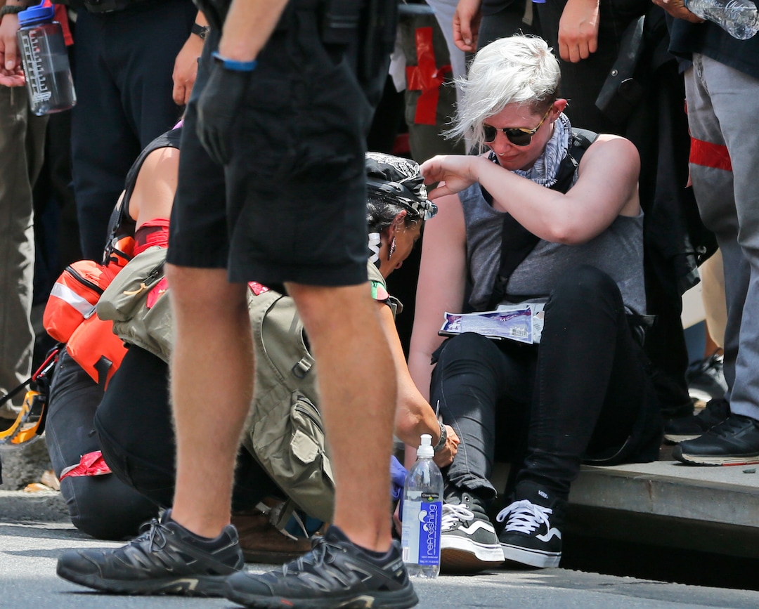 Rescue personnel help injured people after a car ran into a large group of protesters after an white nationalist rally in Charlottesville, Va., Saturday, Aug. 12, 2017. The nationalists were holding the rally to protest plans by the city of Charlottesville to remove a statue of Confederate Gen. Robert E. Lee. There were several hundred protesters marching in a long line when the car drove into a group of them.  (AP Photo/Steve Helber)