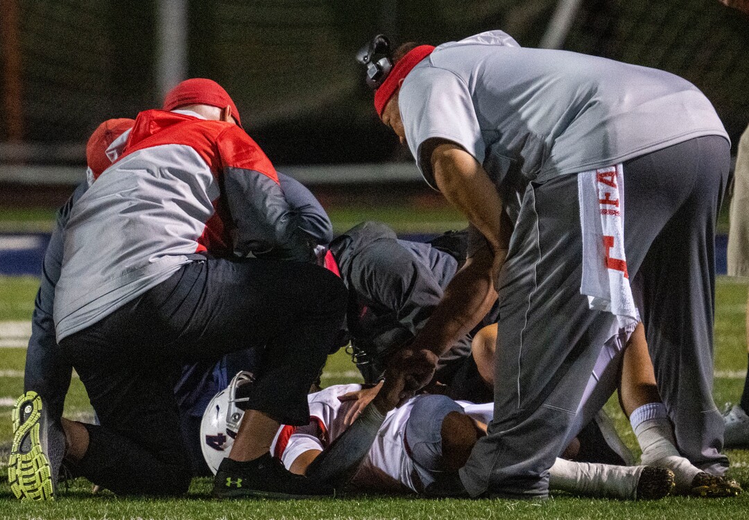 (Rick Egan | The Salt Lake Tribune) Coaches and medical personnel gather around East High Quarterback Siona Vailahi (4) after he was knocked down by a hard hit, in prep football action between Corner Canyon Chargers and the East Leopards, on Saturday, Aug. 21, 2021. He did not return to the game.