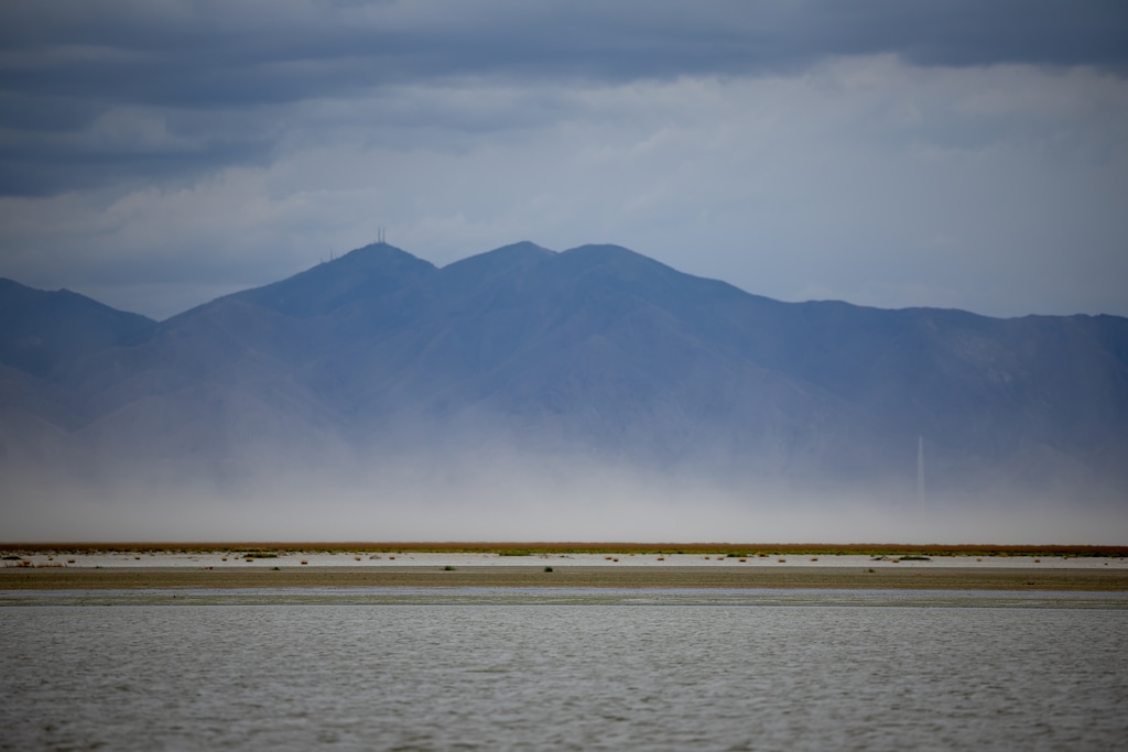 (Spenser Heaps | Pool) Dust blows off dry lakebed of the Great Salt Lake as seen from Farmington Bay on Friday, Aug. 19, 2022.