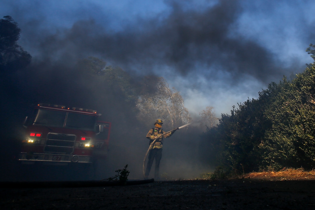 (Ringo H.W. Chiu | AP) Firefighter Brett Reed battles a wildfire near a ranch in Simi Valley, Calif., Wednesday, Oct. 30, 2019.