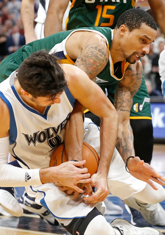 Minnesota Timberwolves' Ricky Rubio, left, of Spain, hits the floor as he and Utah Jazz's George Hill struggle for control of the ball during the second half of an NBA basketball game Saturday, Jan. 7, 2017, in Minneapolis.  (AP Photo/Jim Mone)