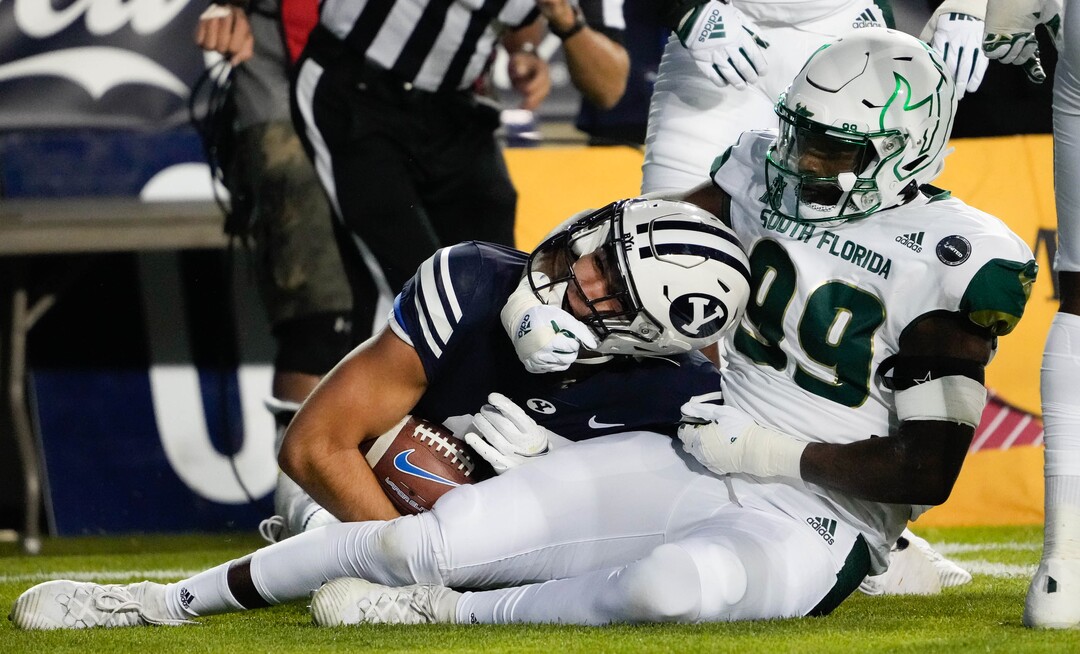 (Francisco Kjolseth | The Salt Lake Tribune) South Florida Bulls defensive end Ryan Thaxton (99) pulls on Brigham Young Cougars wide receiver Puka Nacua (12) in game action between the Brigham Young Cougars and the South Florida Bulls at LaVell Edwards Stadium in Provo, Saturday, Sept. 25, 2021.