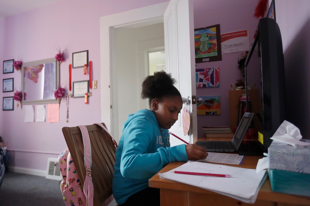 FILE - In this April 9, 2020, file photo, Sunnyside Elementary School fourth-grader Miriam Amacker does school work in her room at her family's home in San Francisco. Teachers across the country report their attempts at distance learning induced by the pandemic are failing to reach large numbers of students. (AP Photo/Jeff Chiu, File)